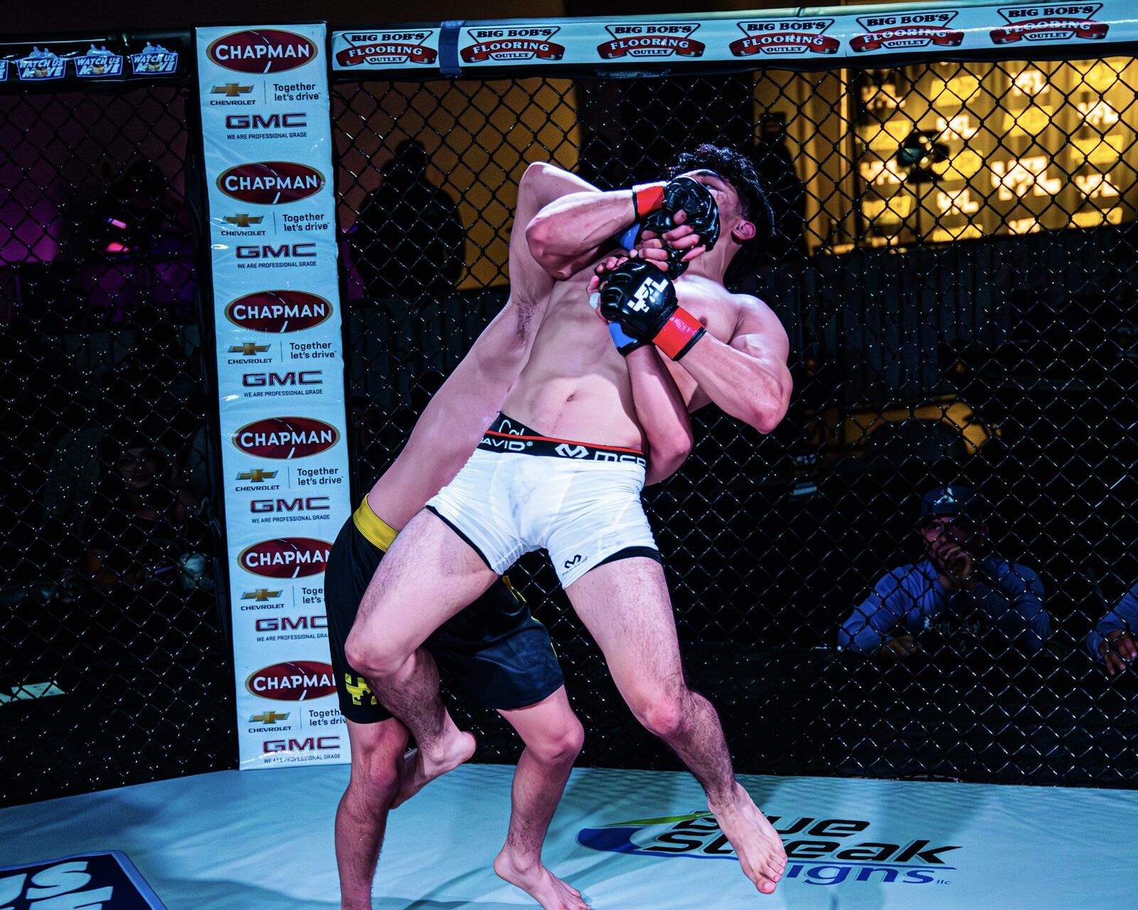 YFL fighter landing a punch with Chapman sponsor banners visible