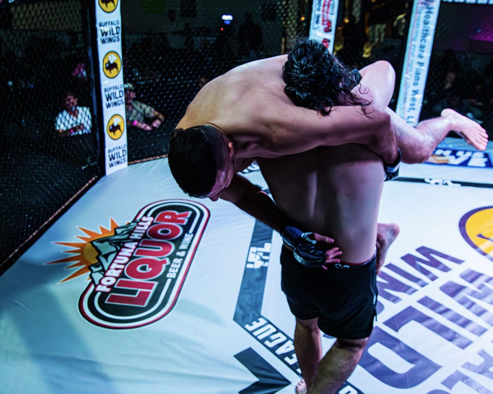 YFL fighter executing a takedown at center cage